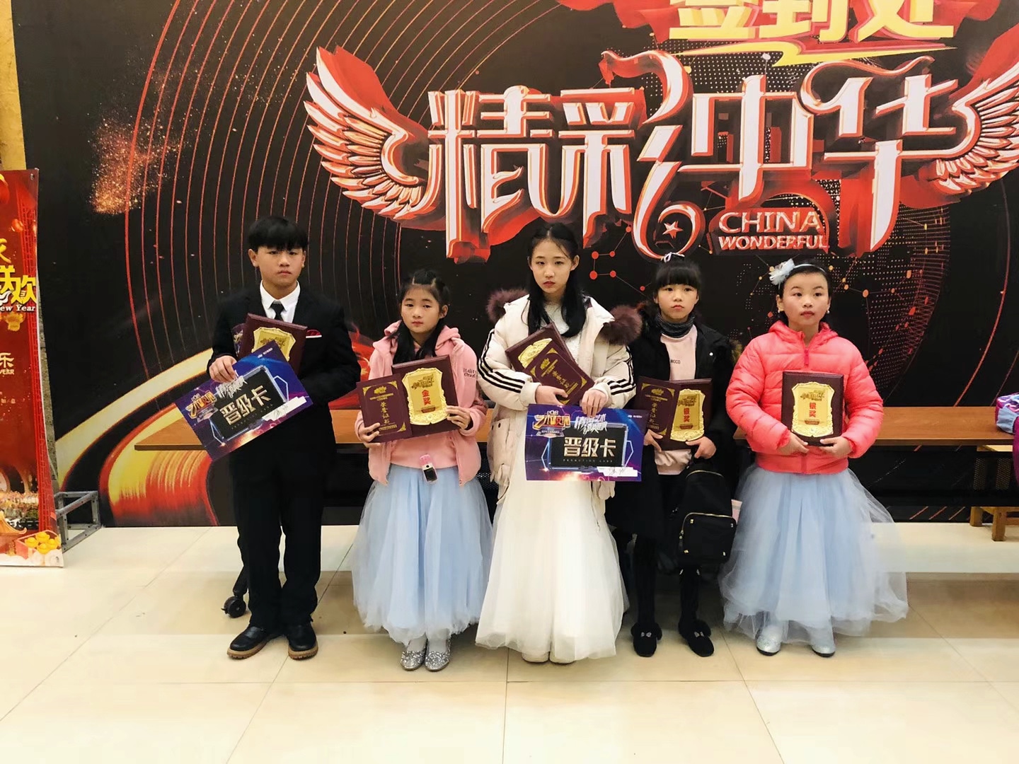 精彩中华背景前五位学生手持真实奖牌和晋级卡的合影